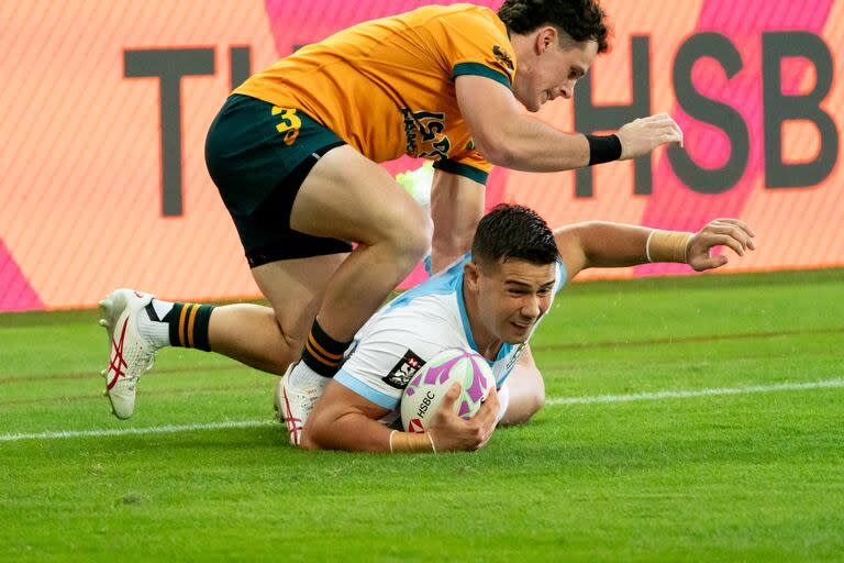 Agustín Fraga se adueña de la pelota ante el asedio de un australiano; derrota de los Pumas 7s en el comienzo del torneo de Singapur