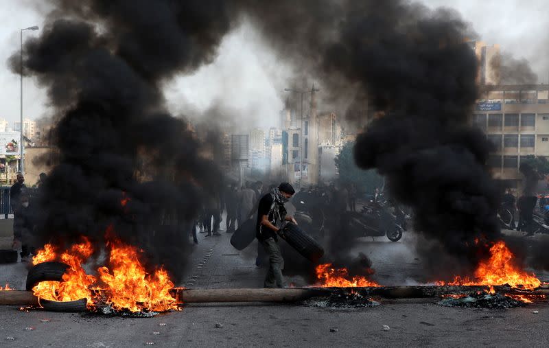 Demonstrators block a road with burning tires during a protest in Beirut