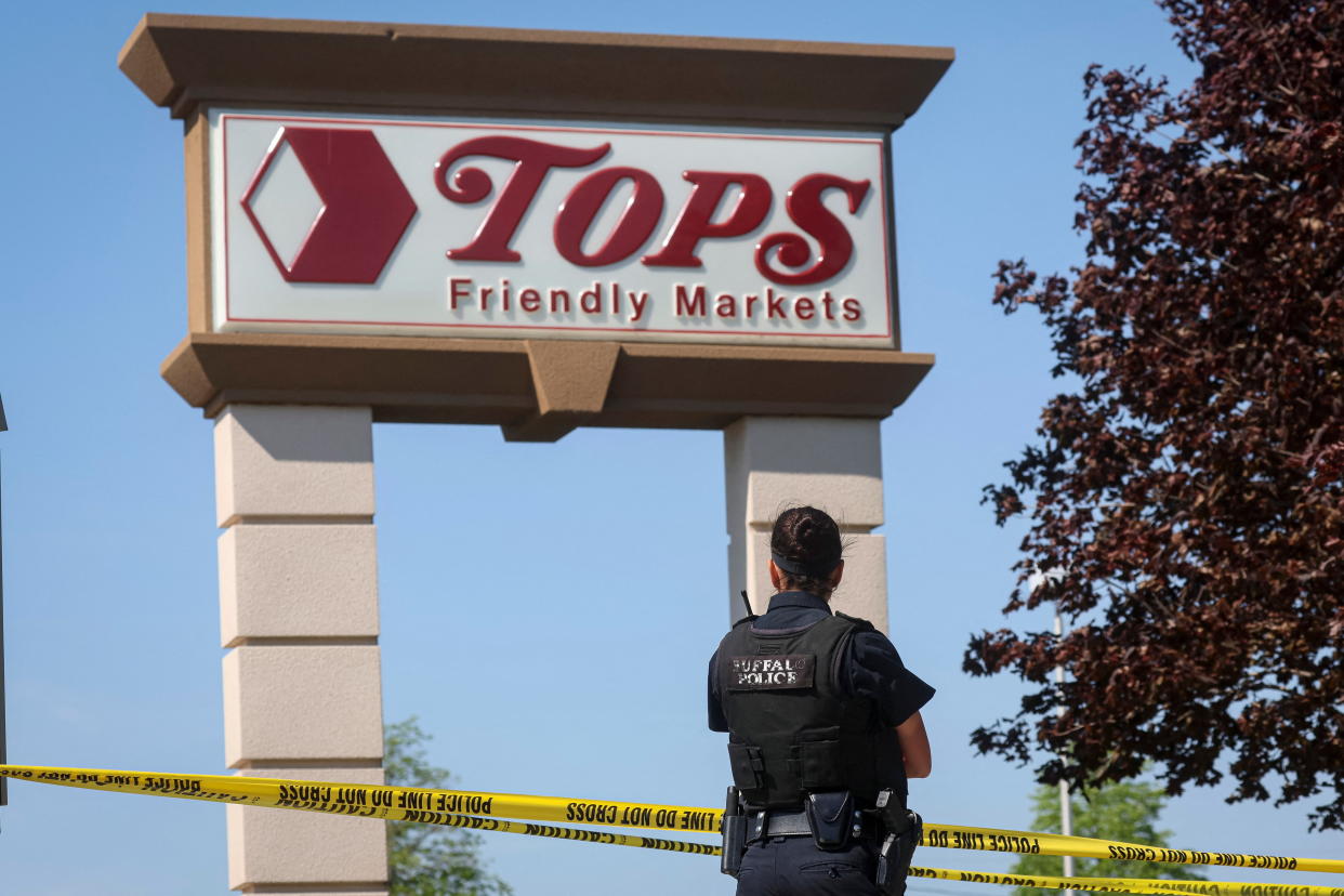 A Buffalo police officer stands at the scene of a shooting at a Tops supermarket.