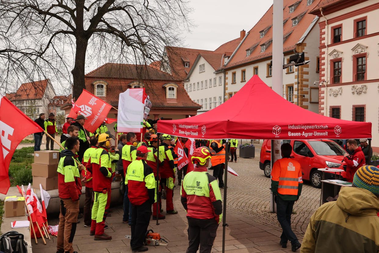 Teilnehmer einer Demonstration von Beschäftigten in der Forstwirtschaft stehen vor der Thüringer Staatskanzlei. (Bild: Bodo Schackow/dpa)