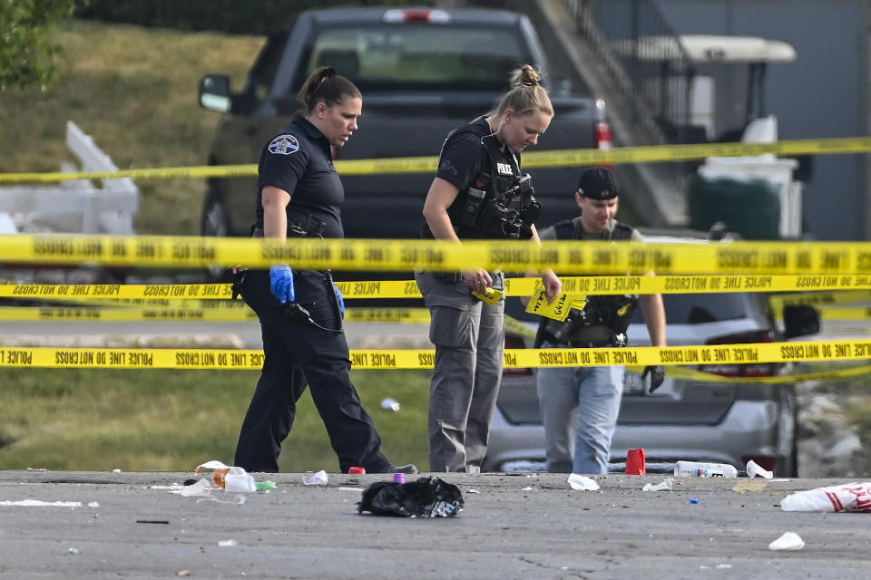 Investigators look over the scene of an overnight mass shooting at a strip mall in Willowbrook, Ill., on June 18, 2023. (Matt Marton / AP)