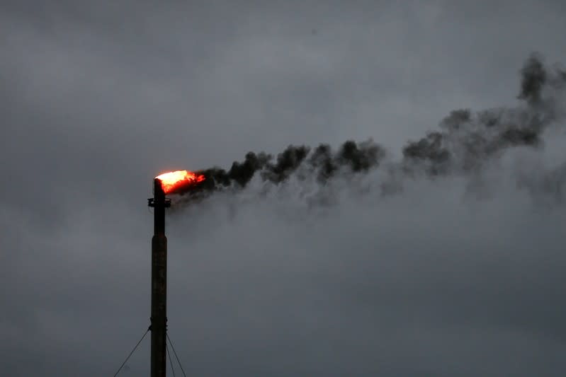 FILE PHOTO: Clouds from Hurricane Harvey are seen in the background as smoke rises from a burn off at an oil refinery in Corpus Christi