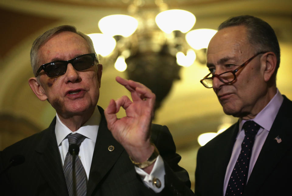 U.S. Senate Minority Leader Harry Reid (D-Nev.) (left) speaks as  Sen. Charles Schumer (D-N.Y.) listens during a news briefing after the weekly Senate Democratic Policy Luncheon on Feb. 24, 2015. Reid was wearing glasses following a recent eye surgery.