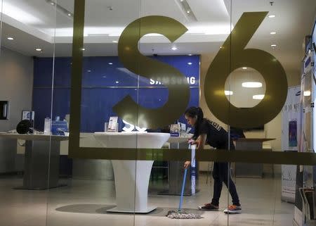 A salesperson cleans the floor at a Samsung showroom as the Galaxy S6 and Galaxy S6 Edge go on sale to the public, at the Grand Indonesia mall in Jakarta, Indonesia, May 8, 2015. REUTERS/Beawiharta/Files