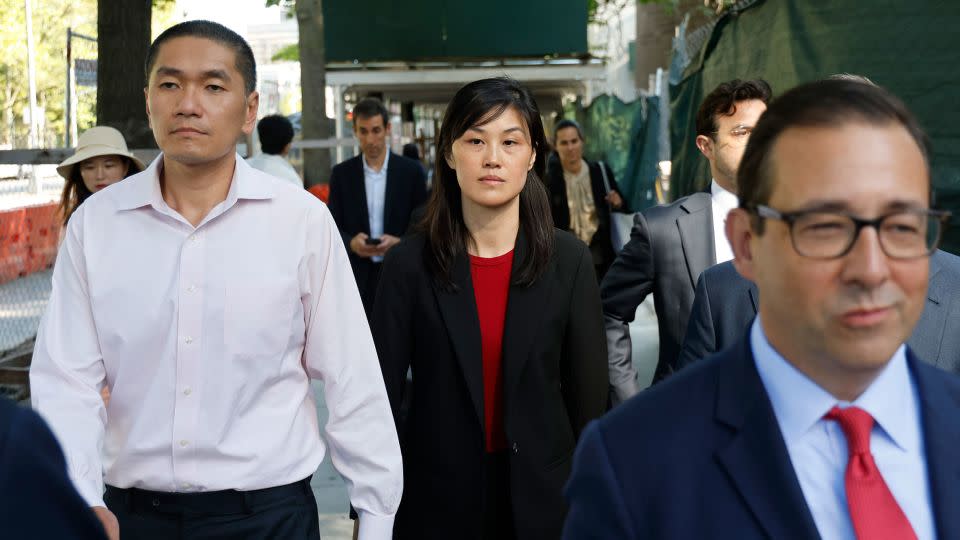 Attorney Seth DuCharme walks in front of Linda Sun, center, and her husband, Christopher Hu, left, as they leave Brooklyn Federal Court after their arraignment, Tuesday. - Corey Sipkin/AP