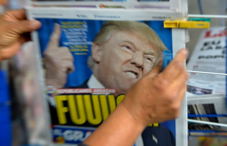A Mexican holds a newspaper with headlines Donald Trump on November 9, 2016 in Mexico City