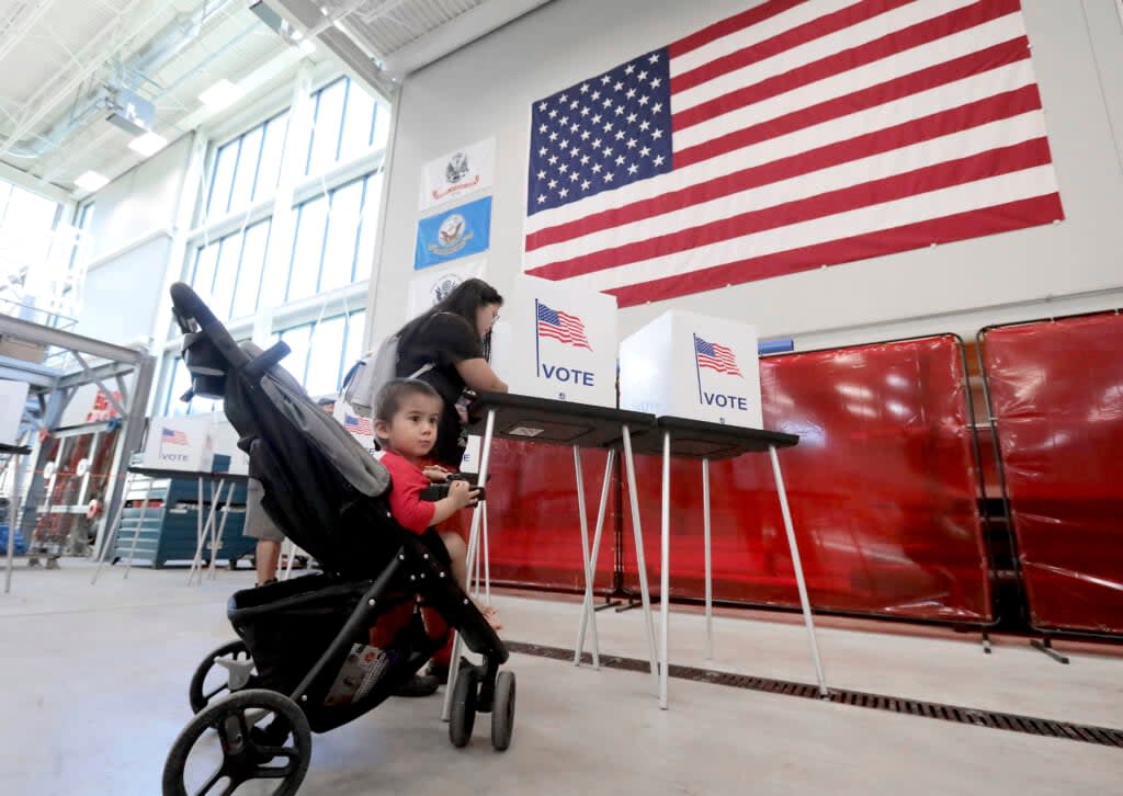 Karen Ruiz fills out her ballot in the Wisconsin partisan primary election during a visit with her son, Grabiel, to her polling place at Steamfitters Local 601 in Madison, Wis. Tuesday, Aug. 9, 2022. (John Hart/Wisconsin State Journal via AP)