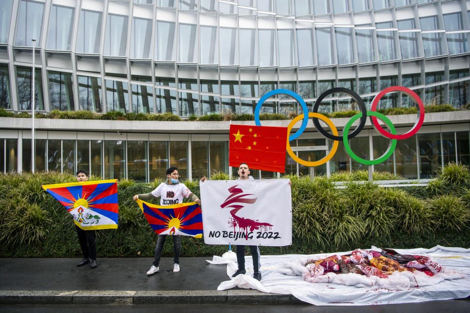 Protesters hold Tibetan flags during a protest against Beijing 2022 Winter Olympics by activists of the Tibetan Youth Association in Europe, in front of the International Olympic Committee, IOC, headquarters in Lausanne, Switzerland, Wednesday, Feb. 3, 2021. A coalition of 180 rights groups is calling for a boycott of next year's Beijing Winter Olympics tied to reported human rights abuses in China. The games are to open on February 4, 2022. The coalition is made up of groups representing Tibetans, Uighurs, Inner Mongolians and others. The group has issued an open letter to governments calling for a boycott of the Olympics “to ensure they are not used to embolden the Chinese government’s appalling rights abuses and crackdowns on dissent.” (Jean-Christophe Bott/Keystone via AP)