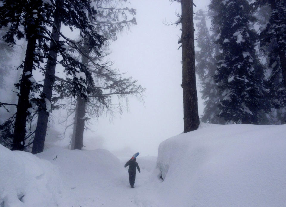 In this photo taken Saturday, Feb. 23, 2013, a Kashmiri resort worker carries skis during heavy snow at Gulmarg, Kashmir. Gulmarg, a ski resort nestled in the Himalayan mountains in Indian-held Kashmir is one of the most militarized places on earth. (AP Photo/Kevin Frayer)