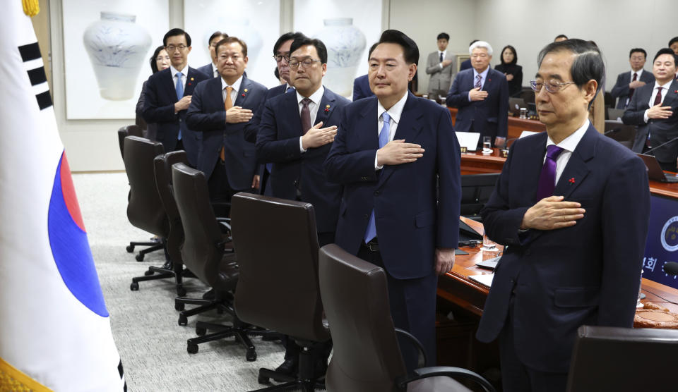 South Korean President Yoon Suk Yeol, second from right, salutes to a national flag during a Cabinet Council meeting at the presidential office in Seoul, South Korea, Tuesday, Dec. 19, 2023. Yoon said during the meeting on Tuesday that a “nuclear-based, powerful Korea-U.S. alliance” would be formed soon. The president's announcement came after North Korea's state media reported Tuesday that it has tested what it says is an intercontinental ballistic missile launch. (Yonhap via AP)