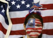 A fan with her face painted in the colours of the U.S. flag, is seen in front of the U.S. flag as she attends the women's preliminary round hockey game between Team USA and Switzerland at the Sochi 2014 Winter Olympic Games February 10, 2014.women's ice hockey at the Sochi 2014 Sochi Winter Olympics February 10, 2014. REUTERS/Jim Young (RUSSIA - Tags: SPORT ICE HOCKEY OLYMPICS TPX IMAGES OF THE DAY)