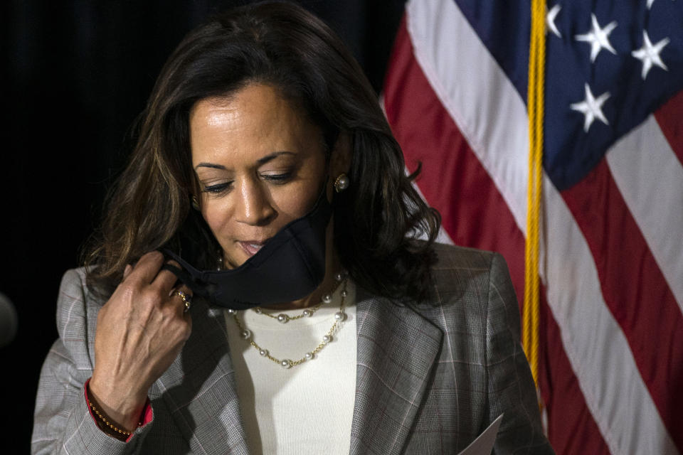 Democratic presidential candidate former Vice President Joe Biden's running mate Sen. Kamala Harris, D-Calif., removes her face mask as she prepares to speak at the Hotel DuPont in Wilmington, Del., Thursday, Aug. 13, 2020. (AP Photo/Carolyn Kaster)