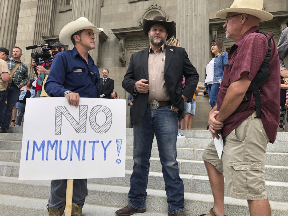 FILE - In this Aug. 24, 2020, file photo, Ammon Bundy, center, who led the Malheur National Wildlife Refuge occupation, stands on the Idaho Statehouse steps in Boise, Idaho. Mainstream and far-right Republicans are battling for control of the party and the state in deeply conservative Idaho. (AP Photo/Keith Ridler, File)