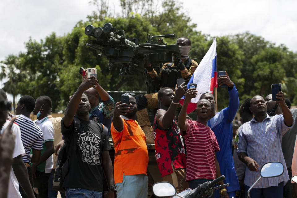 Supporters of Capt. Ibrahim Traore take selfies with a soldier loyal to Traore in the streets of Ouagadougou, Burkina Faso, Sunday, Oct. 2, 2022. Burkina Faso's new junta leadership is calling for calm after the French Embassy and other buildings were attacked. (AP Photo/Kilayé Bationo)