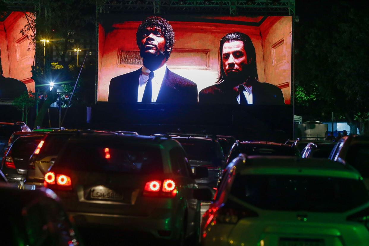 Spectators in their vehicles attend a drive-in movie screening of "Pulp Fiction" amidst the coronavirus (COVID-19) pandemic at Cine Lagoa Drive-in on July 19, 2020, in Rio de Janeiro, Brazil. Cine Lagoa Drive-in originally opened in 1966 and was the first in Latin America. Despite it's closure twenty-seven years ago, the drive-in cinema model resurfaces due to the need for social distancing brought about by the coronavirus pandemic.