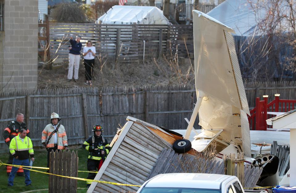 Danbury firefighters look over the scene of a single engine plane that crash behind a home at 159 Southern Blvd in Danbury April 10, 2023. The pilot and passenger walked away from the crash and were transported to Danbury Hospital with minor injuries. 