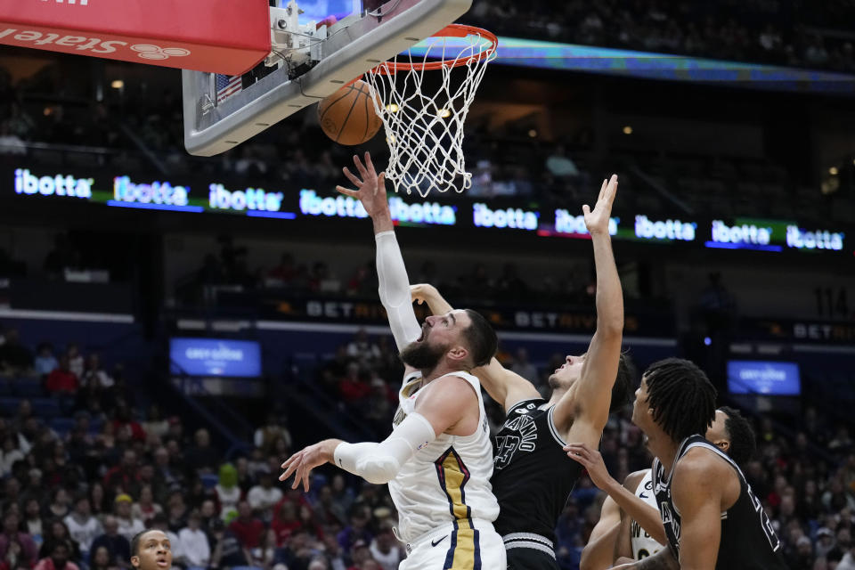 New Orleans Pelicans center Jonas Valanciunas (17) goes to the basket against San Antonio Spurs forward Zach Collins in the first half of an NBA basketball game in New Orleans, Thursday, Dec. 22, 2022. (AP Photo/Gerald Herbert)