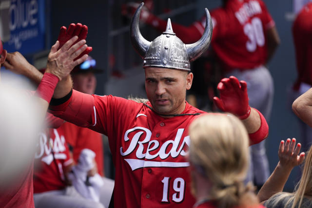 Cincinnati Reds' Spencer Steer (7) places a viking helmet on the head of  Elly De La Cruz (44) after Cruz hit a home run during the second inning of  a baseball game