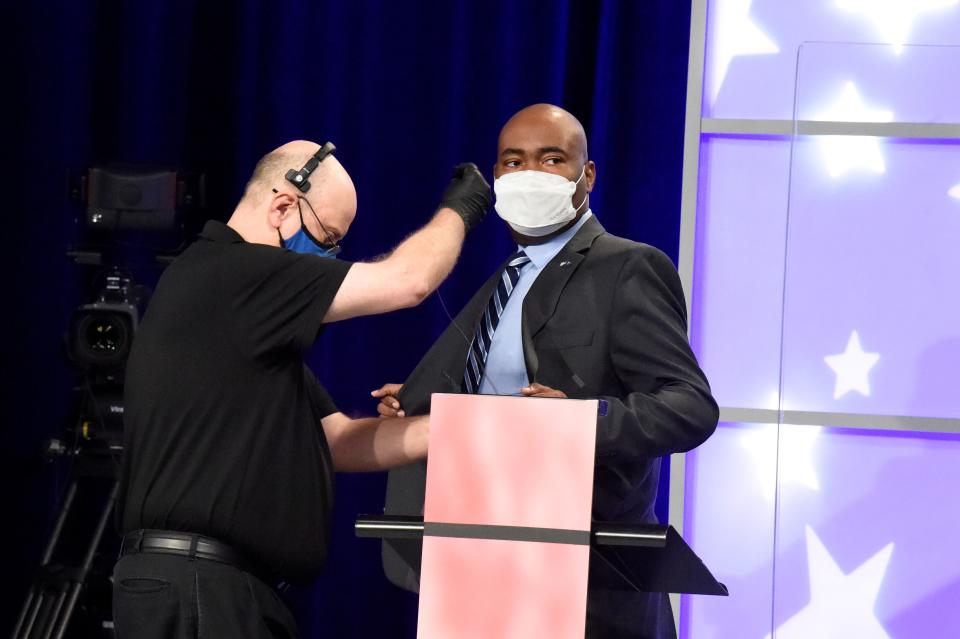 Democratic challenger Jaime Harrison, right, is fitted for a microphone before a debate with U.S. Sen. Lindsey Graham of South Carolina on Friday, Oct. 30, 2020, in Columbia, S.C. (AP Photo/Meg Kinnard)