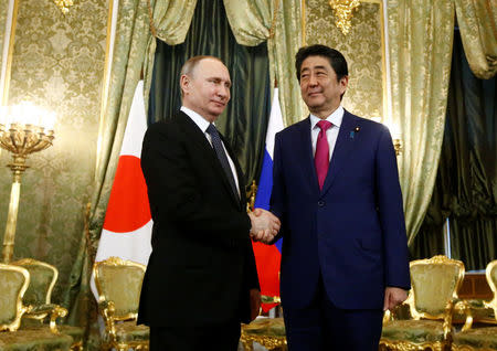 Russian President Vladimir Putin shakes hands with Japanese Prime Minister Shinzo Abe during a meeting at the Kremlin in Moscow, Russia April 27, 2017. REUTERS/Sergei Karpukhin