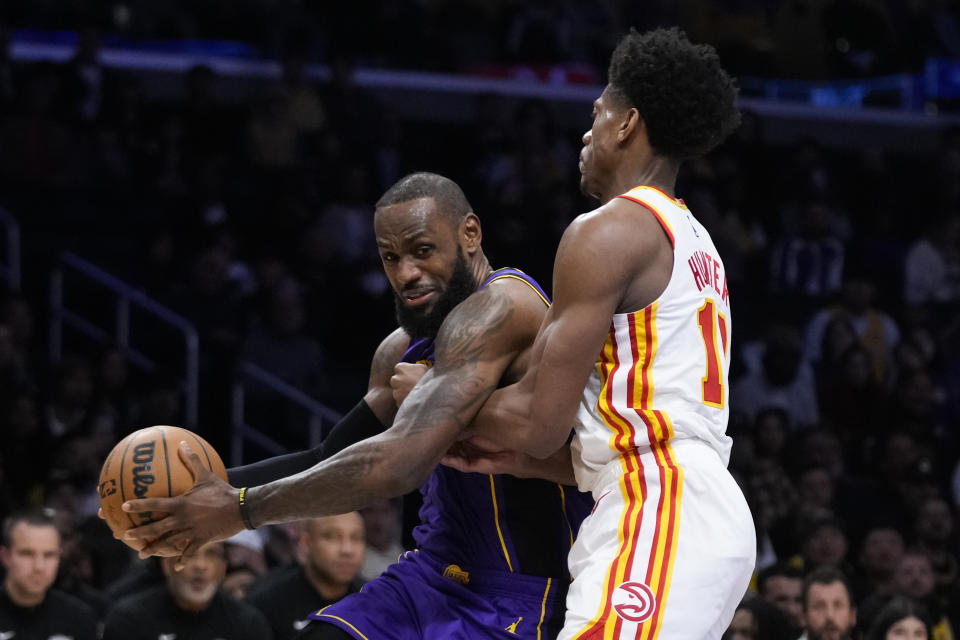 Los Angeles Lakers' LeBron James, left, is defended by Atlanta Hawks' De'Andre Hunter during the first half of an NBA basketball game Friday, Jan. 6, 2023, in Los Angeles. (AP Photo/Jae C. Hong)