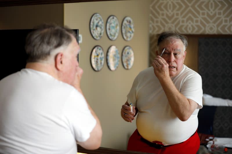 Fred Honerkamp, applies make-up as he prepares to wear his Santa Claus outfit, before visiting Jerusalem's Old City together with a group of Santa Clauses from around the world, at a hotel in Jerusalem