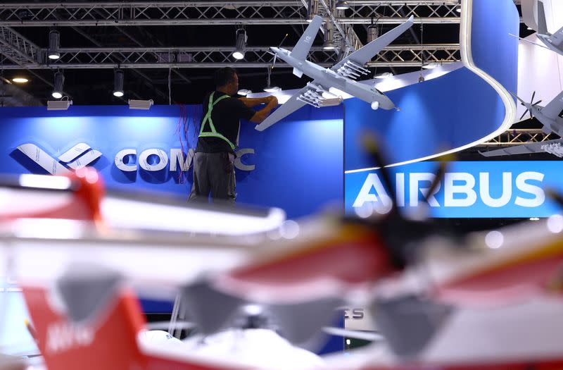 A worker fixes cables at the Comac booth ahead of the Singapore Airshow at Changi Exhibition Centre in Singapore