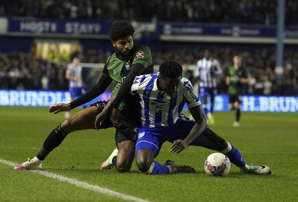 Coventry City's Ellis Simms, left, and Sheffield Wednesday's Di'Shon Bernard battle for the ball during their English FA Cup fourth round soccer match at Hillsborough, Sheffield, England, Friday, Jan. 26, 2024. (Martin Rickett/PA via AP)