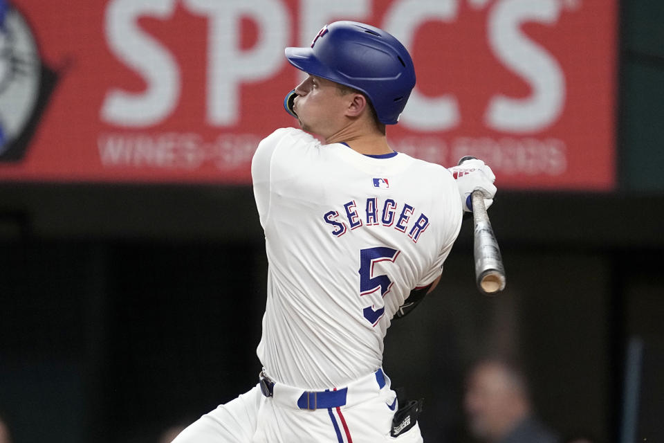 Texas Rangers' Corey Seager follows through on a run-scoring double against the San Diego Padres in the third inning of a baseball game, Wednesday, July 3, 2024, in Arlington, Texas. Marcus Semien scored on the hit. (AP Photo/Tony Gutierrez)