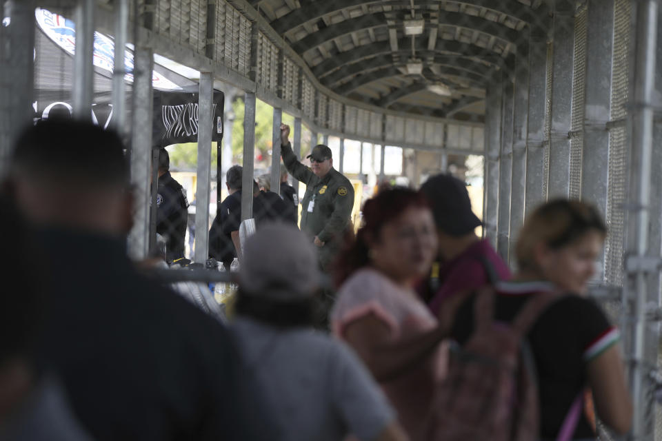 Migrants stand on the closed Gateway International Bridge that connects downtown Matamoros, Mexico with Brownsville, Thursday, Oct. 10, 2019. Migrants wanting to request asylum camped out on the international bridge leading from Mexico into Brownsville, Texas, causing a closure of the span. (AP Photo/Fernando Llano)