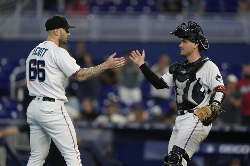 Miami Marlins relief pitcher Tanner Scott (66) and catcher Nick Fortes congratulate each other after the Marlins beat the Colorado Rockies 3-2 during a baseball game, Thursday, June 23, 2022, in Miami. (AP Photo/Wilfredo Lee)