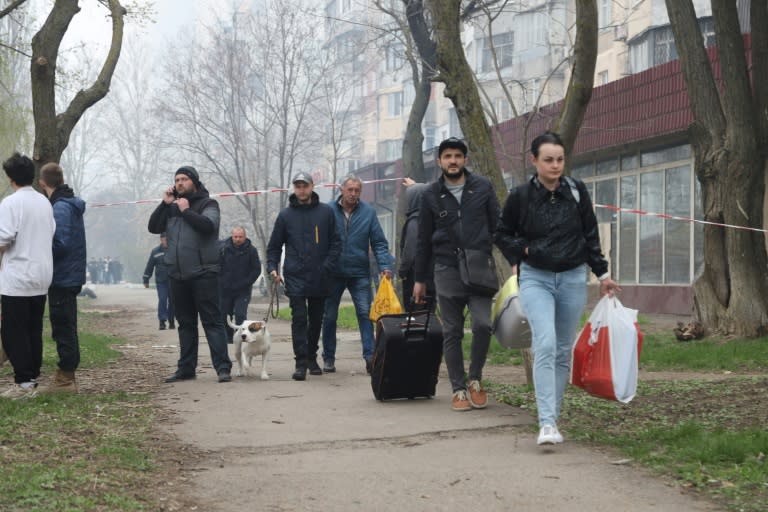 Des habitants fuient les bombardements sur la ville ukrainienne de Kharkiv, le 23 avril 2022 (AFP/Oleksandr GIMANOV)