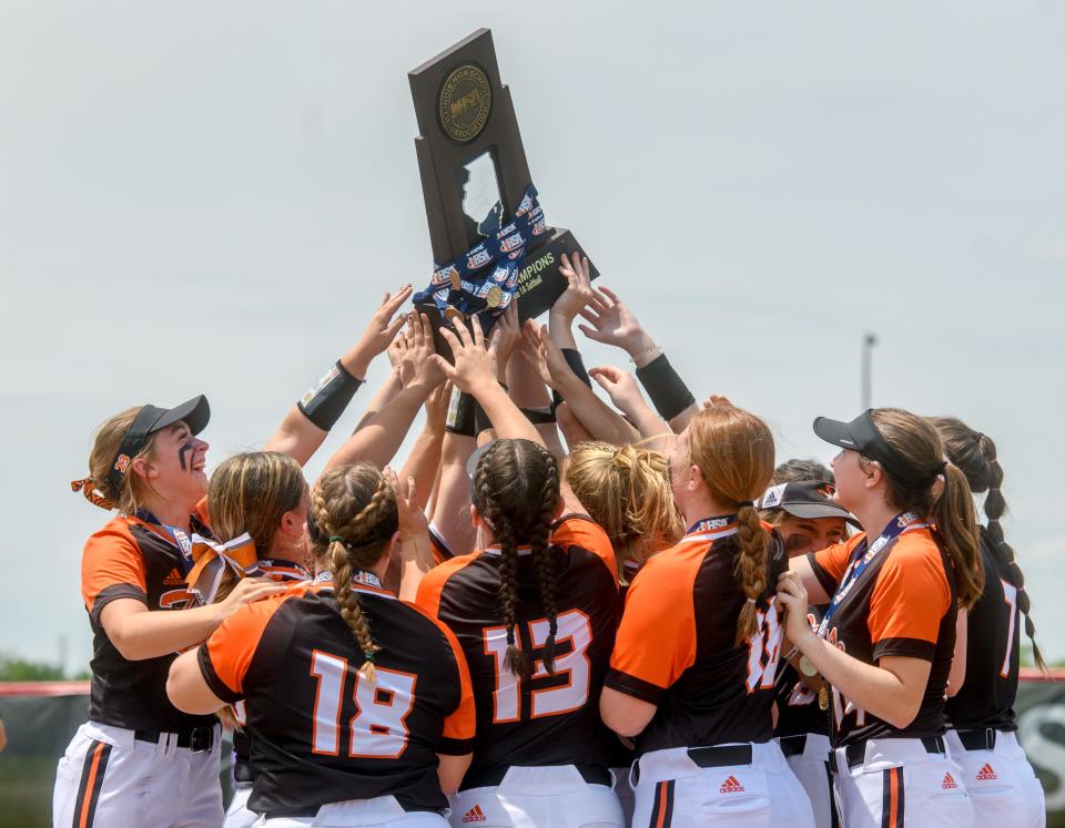 The Illini Bluffs Tigers reach out to touch their Class 1A state softball championship trophy after defeating Casey-Westfield 1-0 in nine innings Saturday, June 4, 2022 at the Louisville Slugger Sports Complex in Peoria. The Tigers defended their 2022 title with a walk-off RBI from junior Lilly Hicks and a one-hit performance from senior pitcher Kierston McCoy.