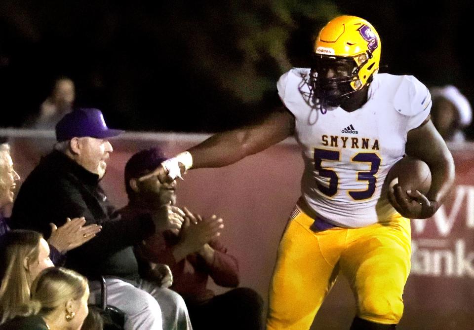 Smyrna defensive lineman Jayden Marable (53) celebrates with fans in the end zone after scoring on a fumble return during a 15-5 win over Riverdale Friday.