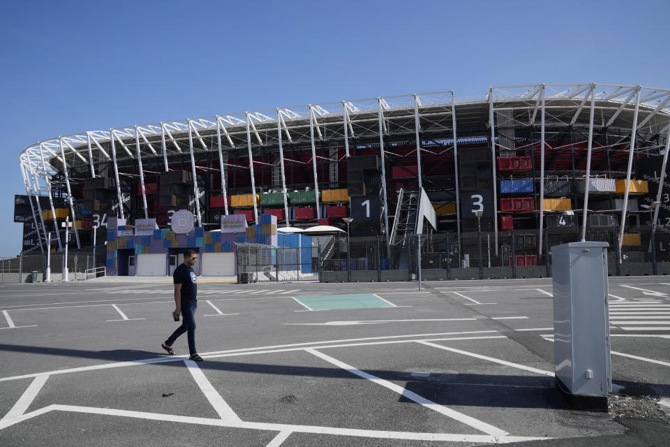 A man walks past the Stadium 974, one of the most distinctive venues created for the World Cup, in Doha, Qatar, Sunday, Jan. 14, 2024. (AP Photo/Aijaz Rahi)