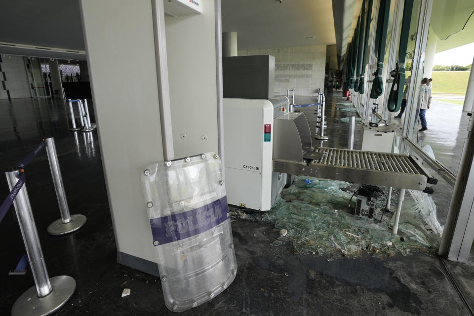 Broken glass lays on the floor of the main hall of Senate the day after Congress was stormed by supporters of Brazil's former President Jair Bolsonaro in Brasilia, Brazil, Monday, Jan. 9, 2023. The protesters also stormed the presidencial office, Planalto Palace, and the Supreme Court. (AP Photo/Eraldo Peres)