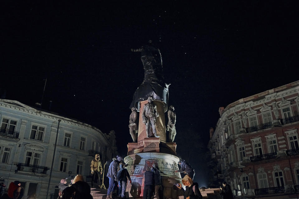 People start to remove the monument to Catherine II, also known as "Monument to the Founders of Odesa" in Odesa, Ukraine, late Wednesday, Dec. 28, 2022. The decision to dismantle the monument consisting of sculptures of Russian Empress Catherine II and her associates was made recently by Odesa residents by electronic voting. (AP Photo/LIBKOS)