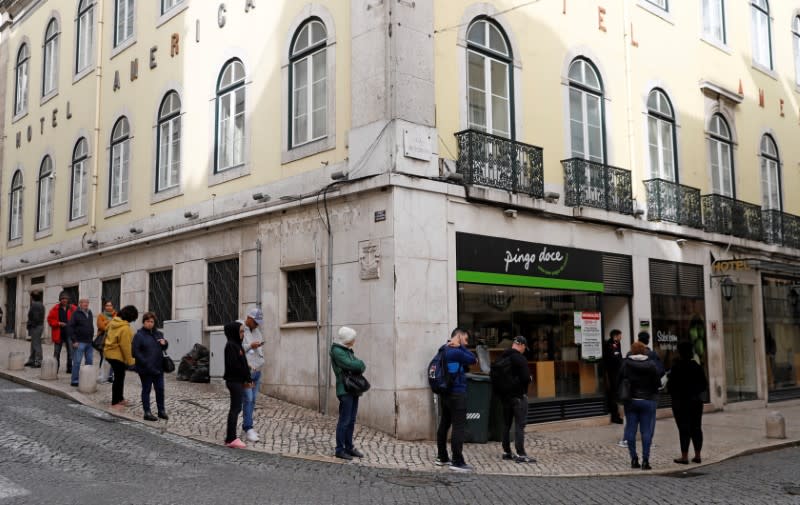 People queue outside of a Pingo Doce supermarket as the spread of the coronavirus disease (COVID-19) continues in downtown Lisbon