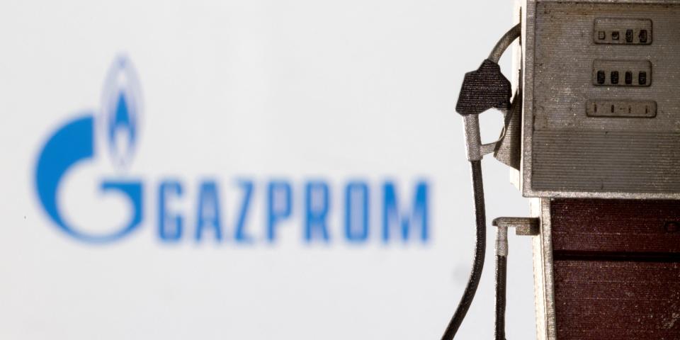 Model of petrol pump is seen in front of Gazprom logo.