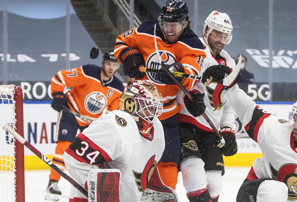 Edmonton Oilers' James Neal (18) and Ottawa Senators' Erik Gudbranson (44) battle in front as Senators goalie Joey Daccord (34) makes a save during second-period NHL hockey game action in Edmonton, Alberta, Monday, March 8, 2021. (Jason Franson/The Canadian Press via AP)