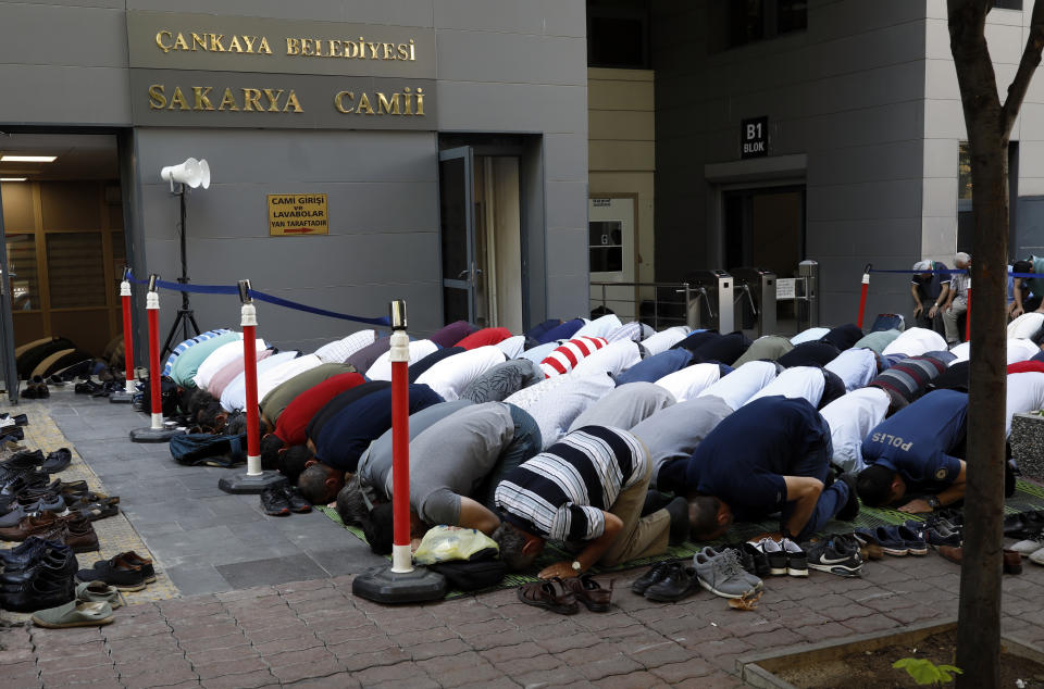 People perform Friday prayers at an open air mosque in Ankara, Turkey, Friday, Aug. 17, 2018. Turkey and the United States exchanged new threats of sanctions Friday, keeping alive a diplomatic and financial crisis.(AP Photo/Burhan Ozbilici)