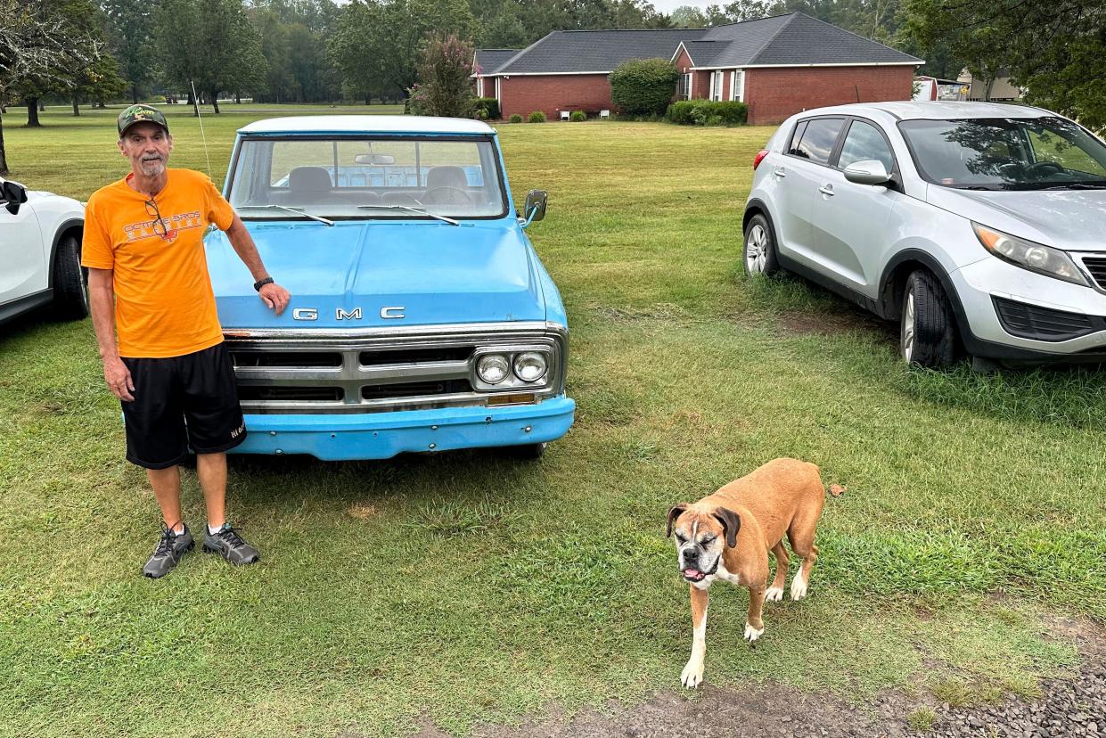 Ricky Dority poses for a photo with his 1969 GMC pickup and his family dog "Boots" in September outside his family's home in Greenwood, Arkansas. Dority was freed from prison this summer with the help of students from Oklahoma City University's Innocence Project.