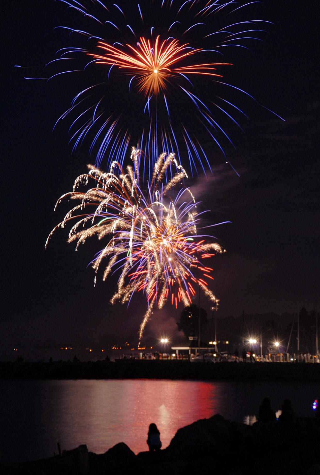 A lone fireworks viewer finds the perfect spot to watch the fireworks over the Petoskey waterfront.