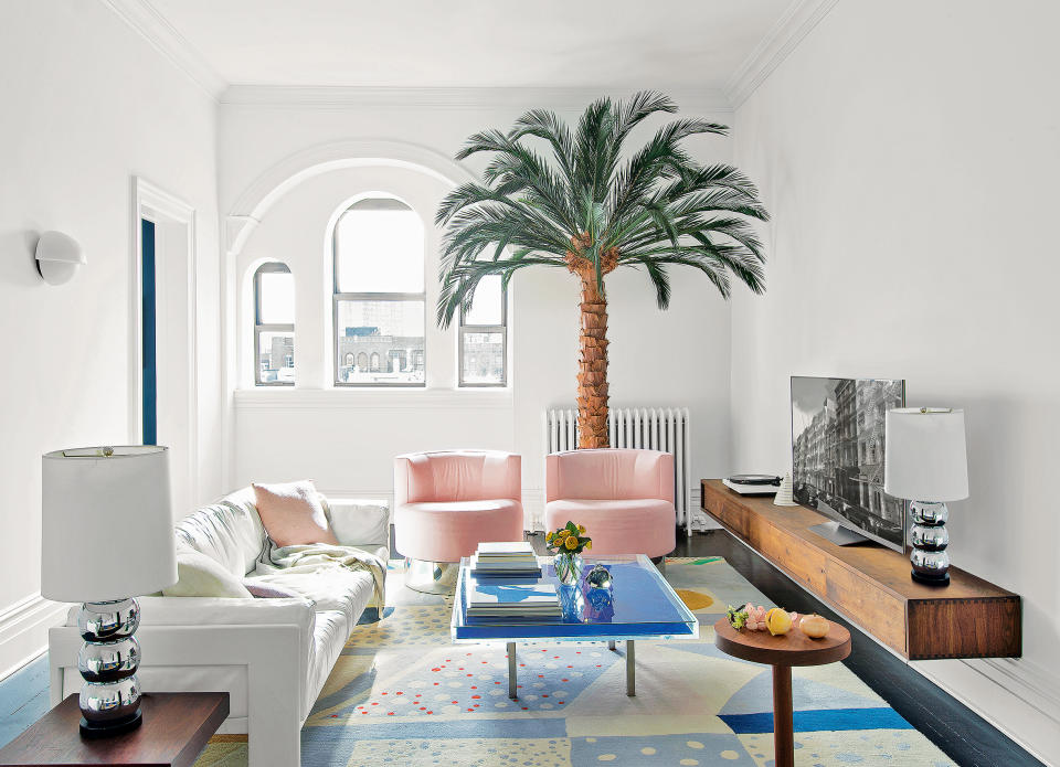 Small living room with  pink chairs and floating TV unit