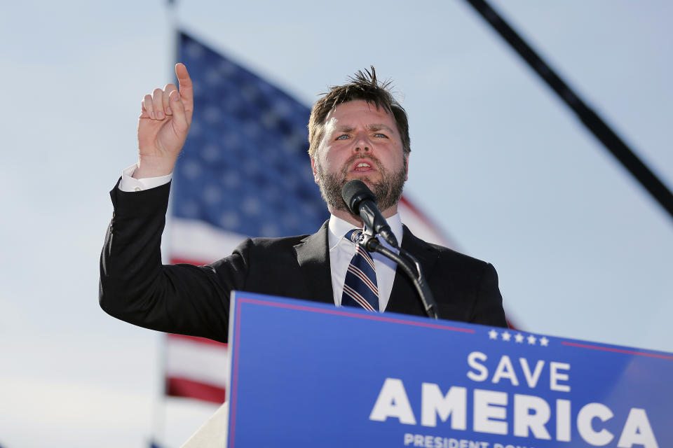 Republican Senate candidate J.D. Vance at a podium with a poster saying Save America.