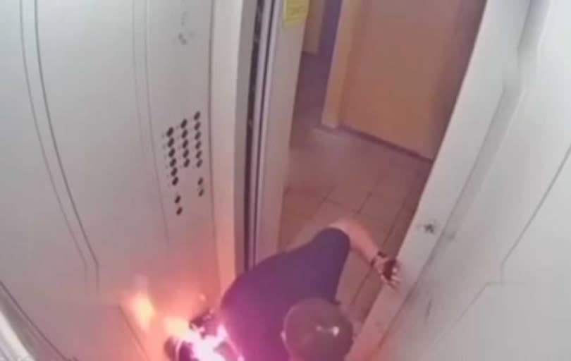 男子左手已燒到焦黑，無力的跪趴在電梯口。（圖／翻攝自Vlad Orza YouTube）