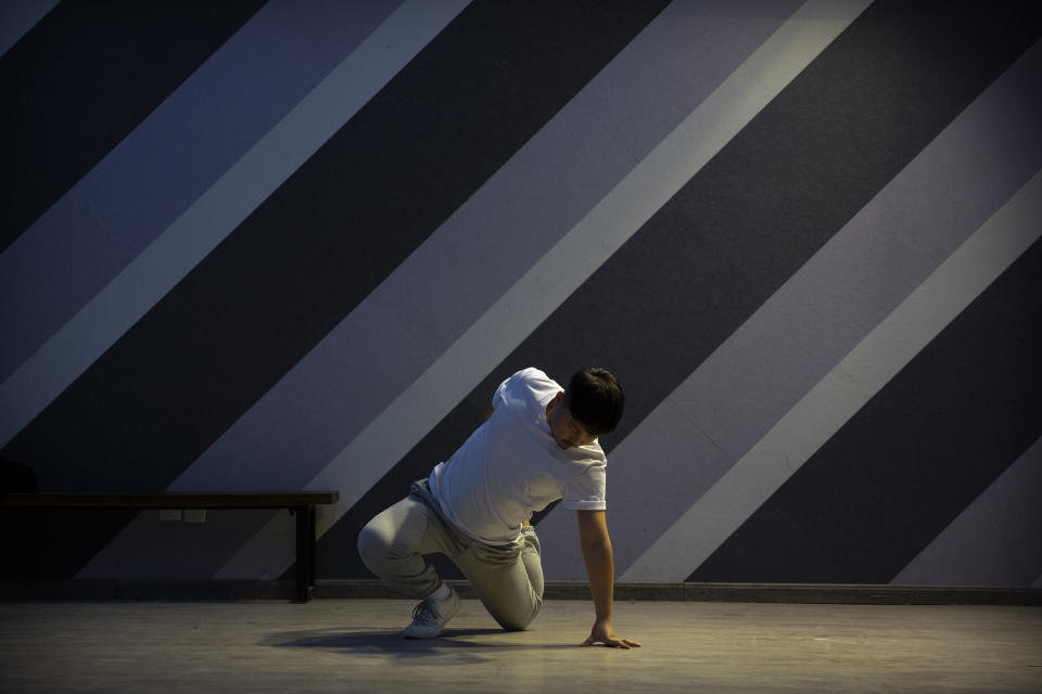 Otter, a member of the Chinese music group Produce Pandas, stretches as he warms up before practicing dance choreography during rehearsals in Beijing, Thursday, April 15, 2021. The Produce Pandas proudly call themselves "the first plus-sized boy band in China." That's a radical departure from the industry standard set by Korean super groups such as BTS, whose lanky young members are sometimes referred to in China as "little fresh meat." (AP Photo/Mark Schiefelbein)