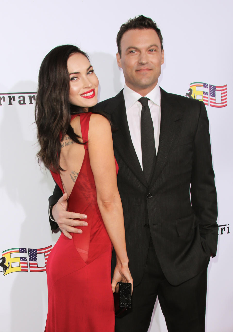 Megan Fox in a red dress with Brian Austin Green in a suit at an event