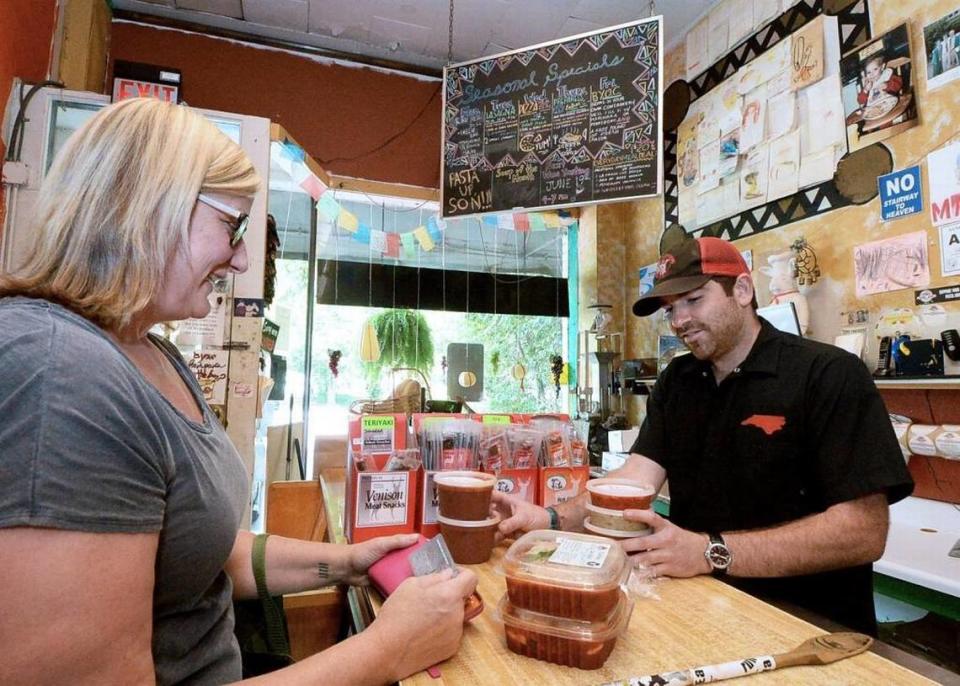 Customer Anne Bullard purchases Pomodoro Sauce, Roasted Red Pepper Pesto and Chicken Involtini at the counter with the help of Pasta and Provisions general manager Dylan George on Wednesday July 8, 2015.