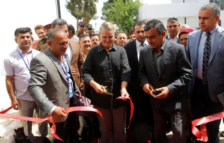 United Nations Development Programme (UNDP) Resident Representative for Iraq Lise Grande (C) cuts the ribbon during the inauguration of a water treatment plant on the outskirts of Qaraqosh, Iraq, May 7, 2017. Picture taken May 7, 2017. REUTERS/Danish Siddiqui